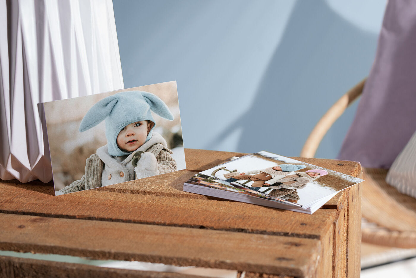 Hübsches Fotobuch und Postkarte auf Holzoberfläche.