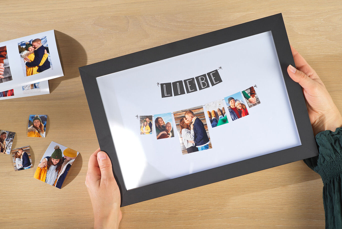 Eine Person hält einen Bilderrahmen mit Fotos und dem Schriftzug "LIEBE".